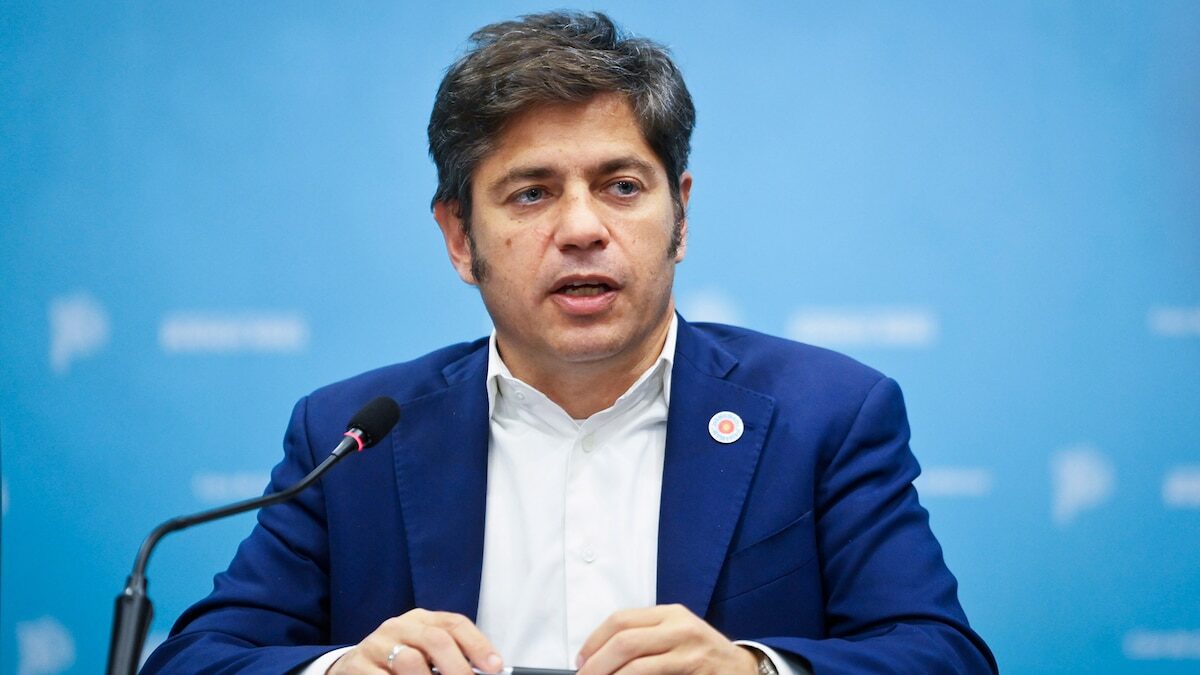 Axel Kicillof durante una conferencia de prensa en un fondo azul