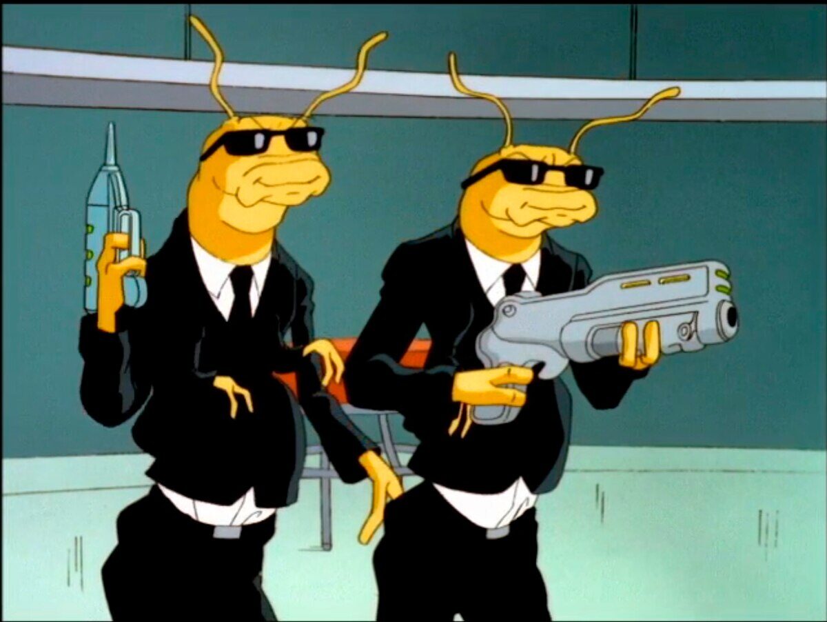 Personajes de Men in Black: La Serie Animada, dos extraterrestres con trajes negros y gafas de sol