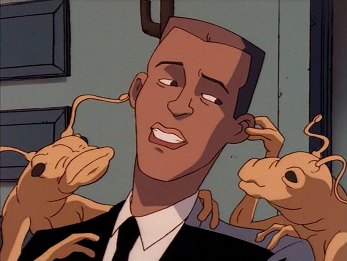 Personaje de Men in Black interactuando con criaturas alienígenas en un entorno animado