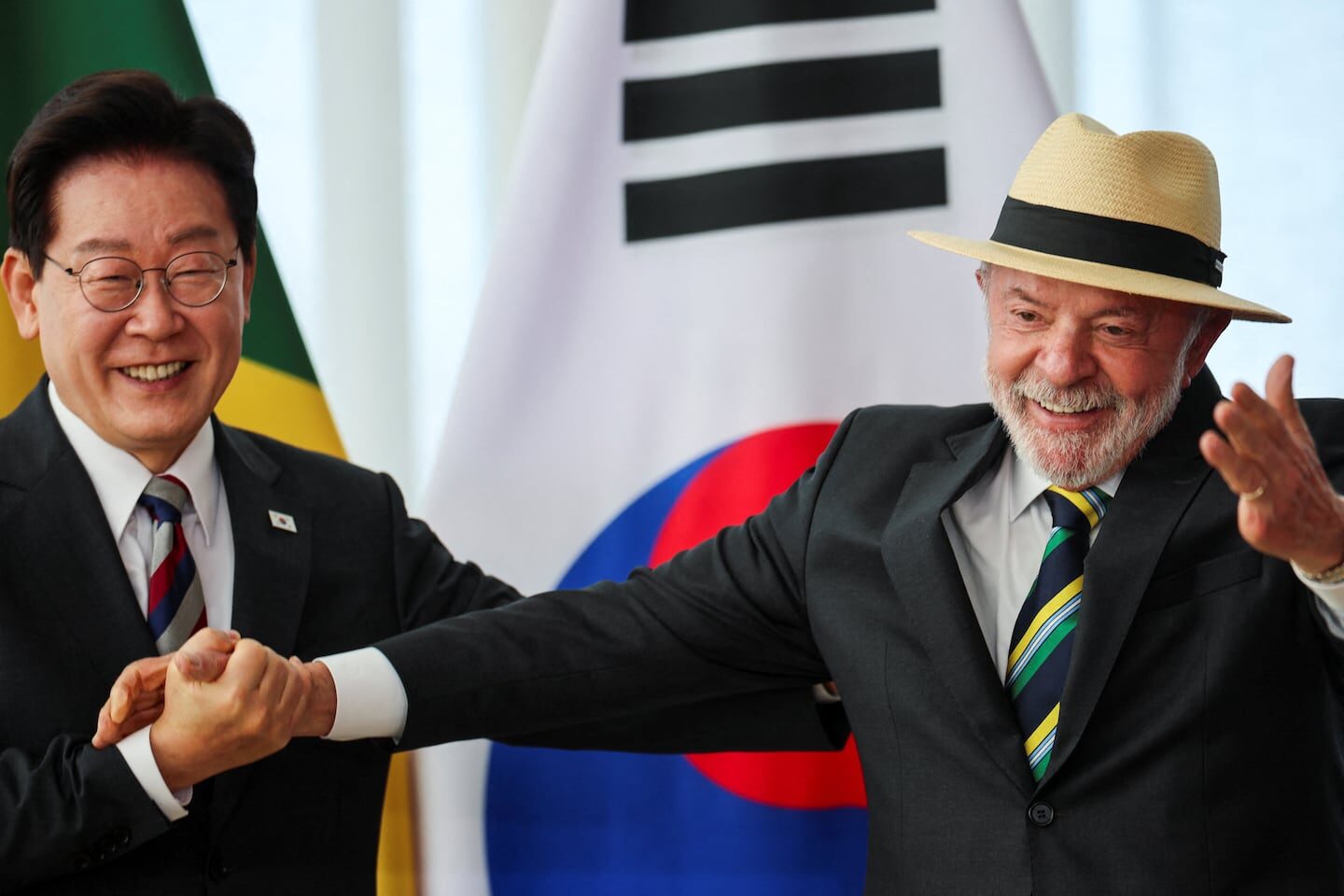 Lula Da Silva y un funcionario surcoreano estrechan manos en un evento oficial