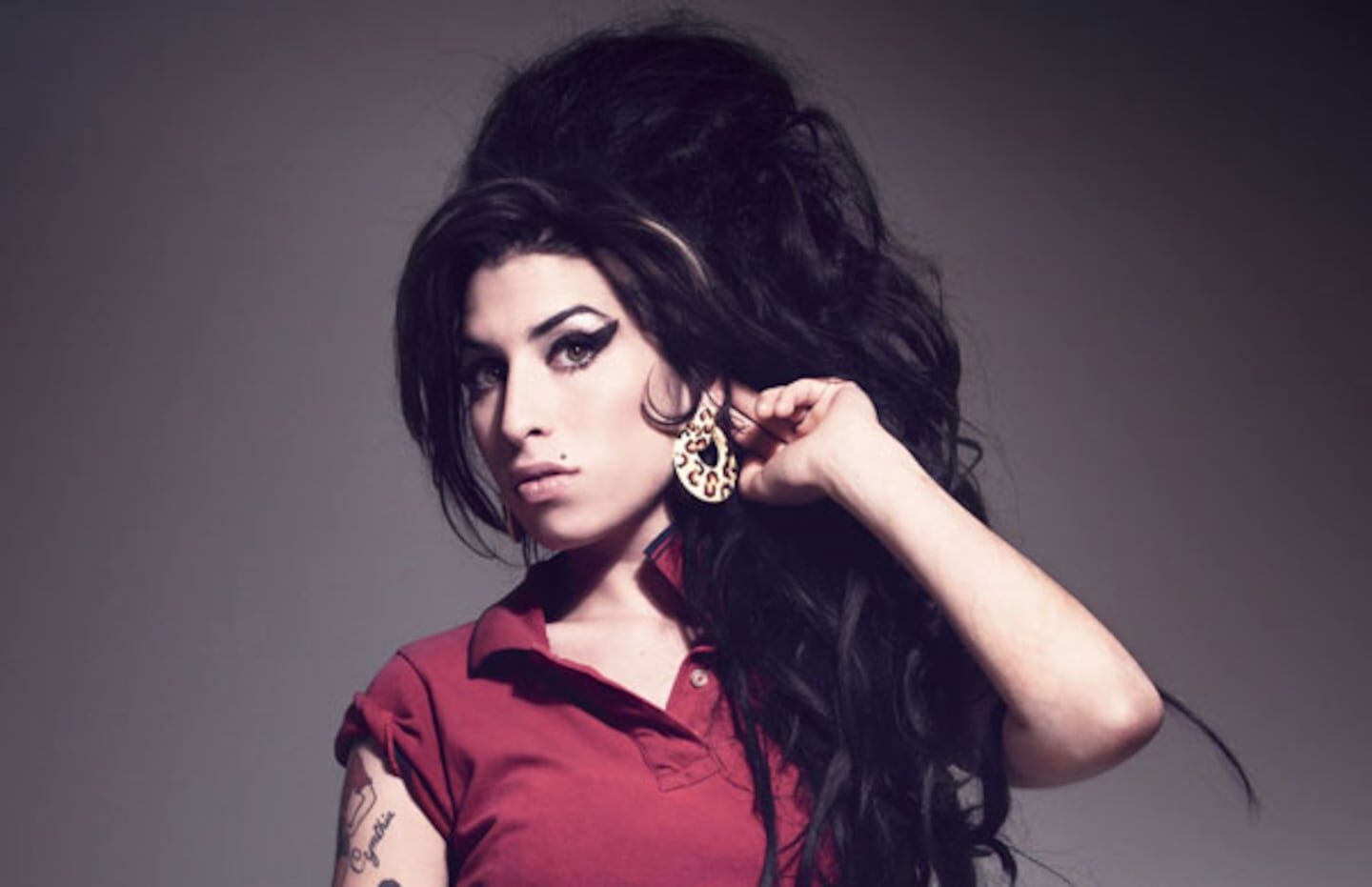 Amy Winehouse con peinado característico y camiseta roja