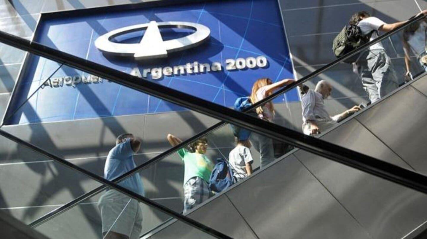 Pasajeros en una escalera mecánica en el Aeropuerto Argentina 2000