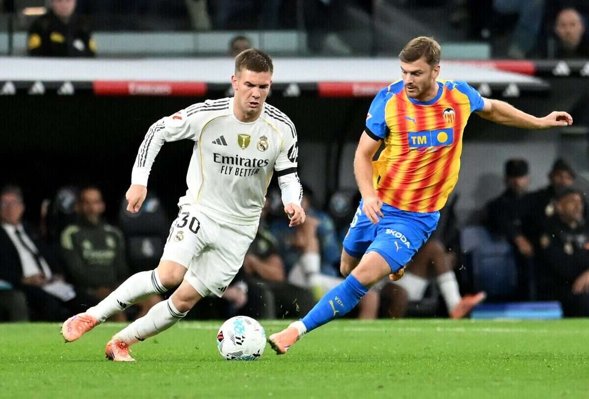 Jugador del Real Madrid driblando a un oponente del Valencia en un partido de fútbol
