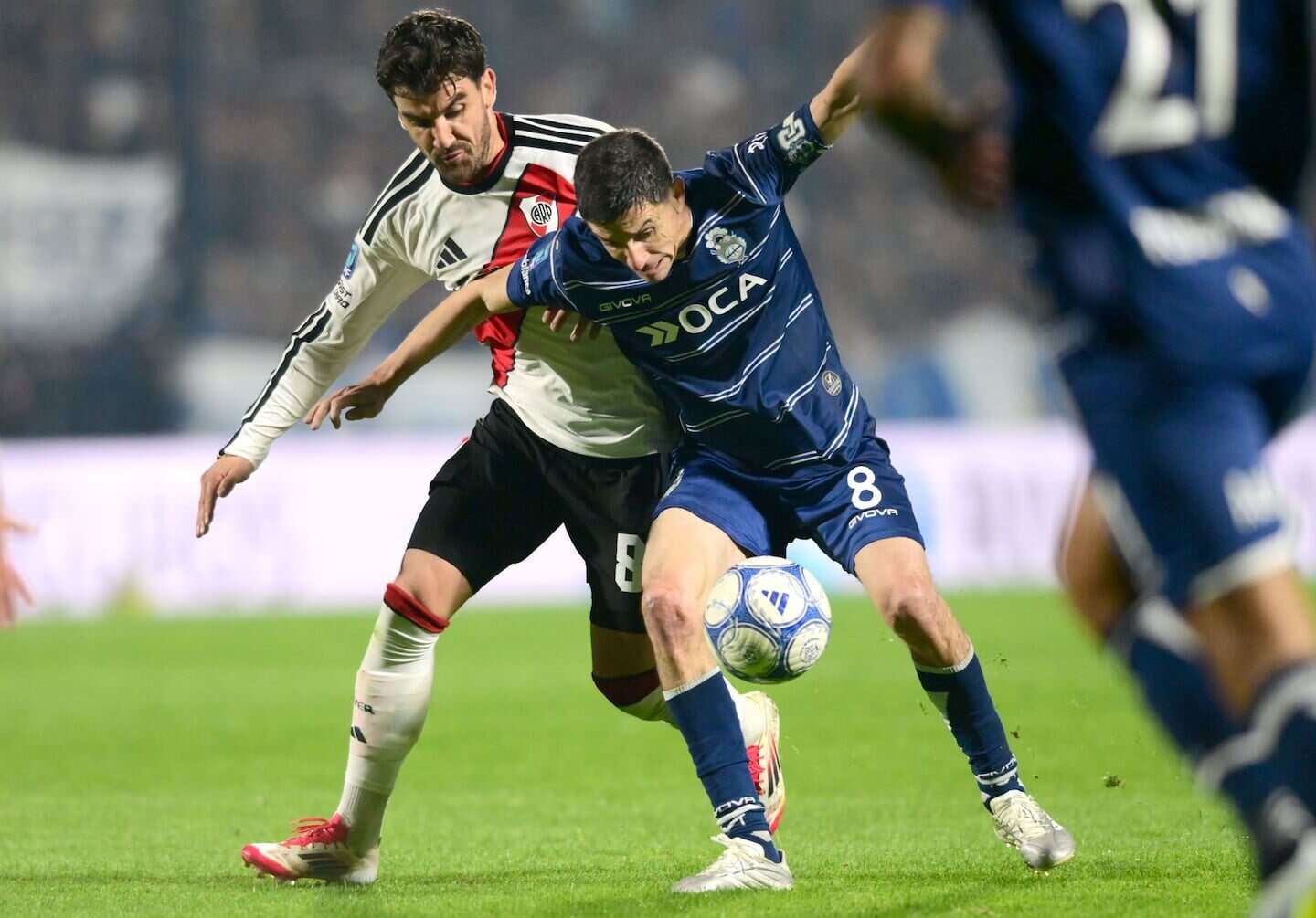 Nacho Fernández luchando por el balón en un partido entre Gimnasia y River Plate