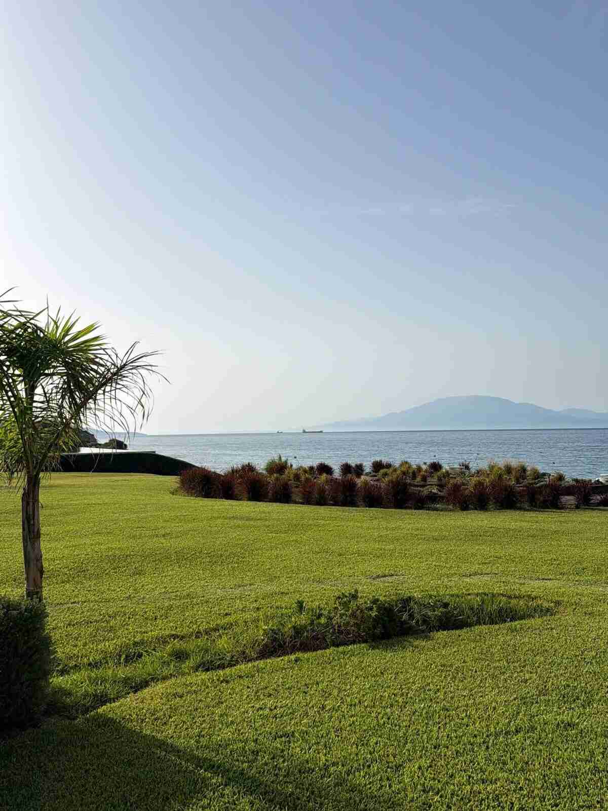 Vista panorámica de un paisaje costero en Grecia con césped verde y mar al fondo