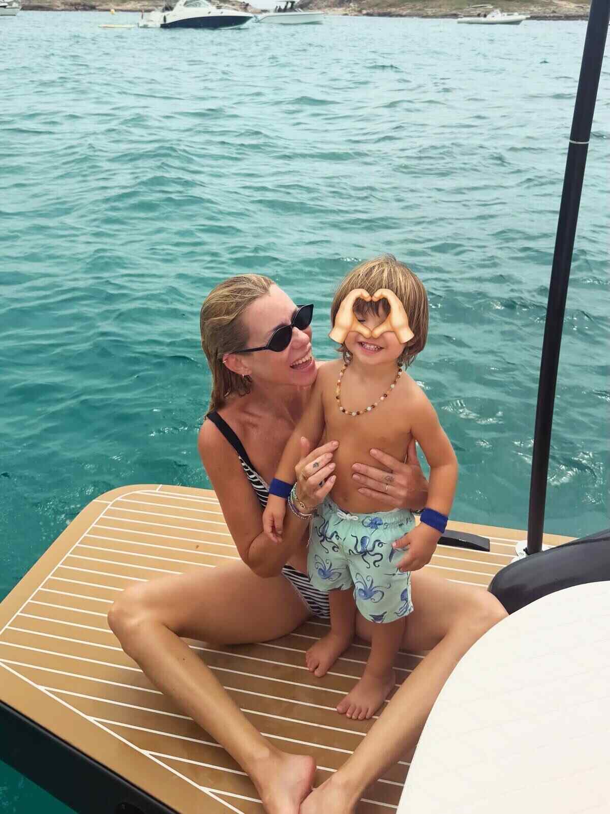 Nicole Neumann sonríe mientras sostiene a su hijo Cruz en un bote en el mar