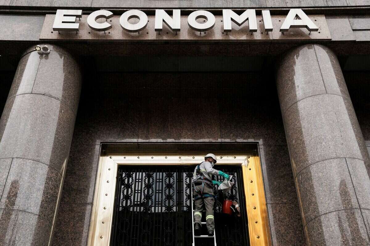 Trabajador realizando mantenimiento en la entrada del Ministerio de Economía en Argentina