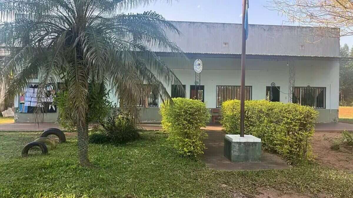 Escuela rural en Corrientes con vegetación y un mástil en el frente