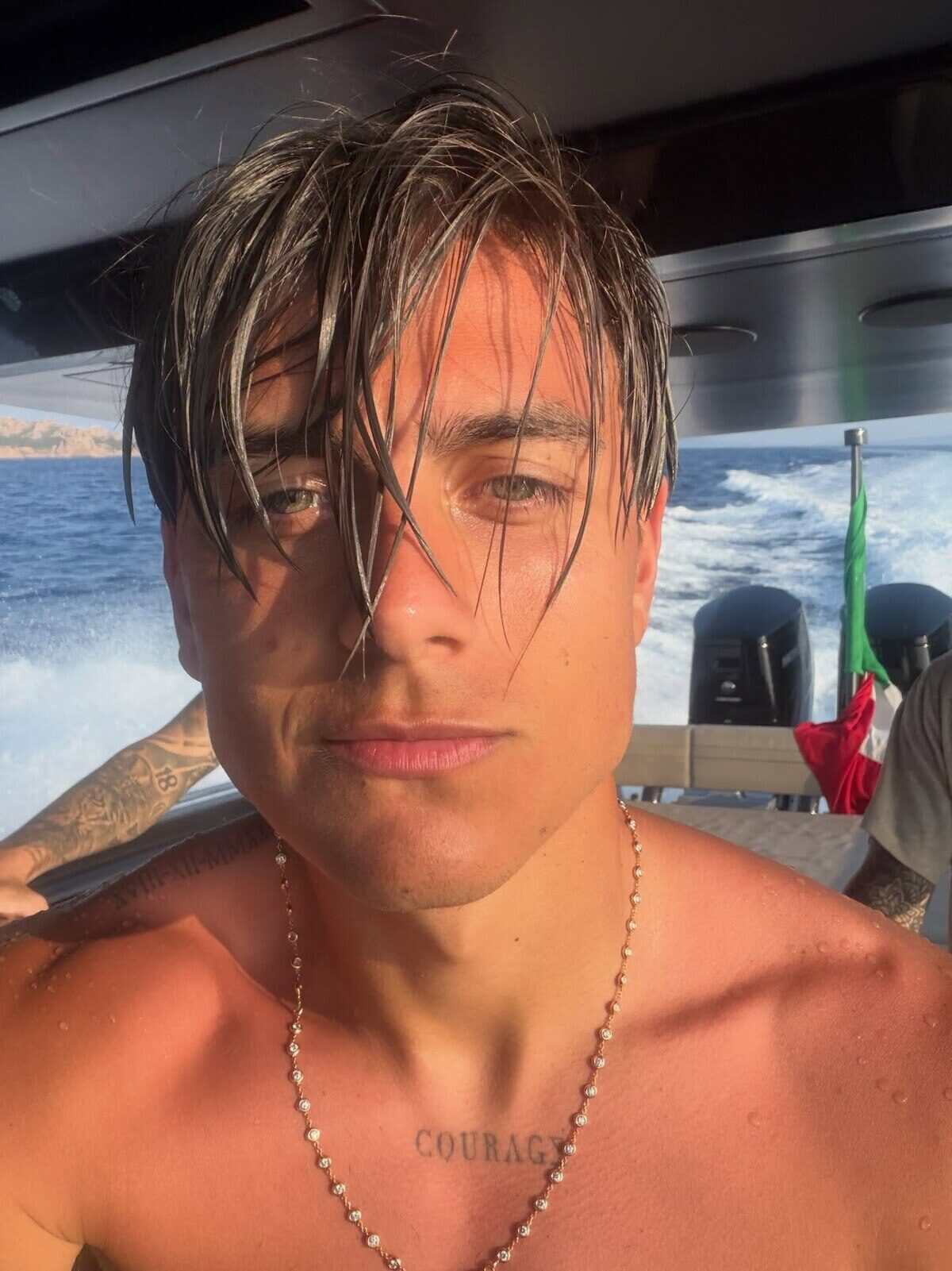 Paulo Dybala posando en un barco con el mar de fondo