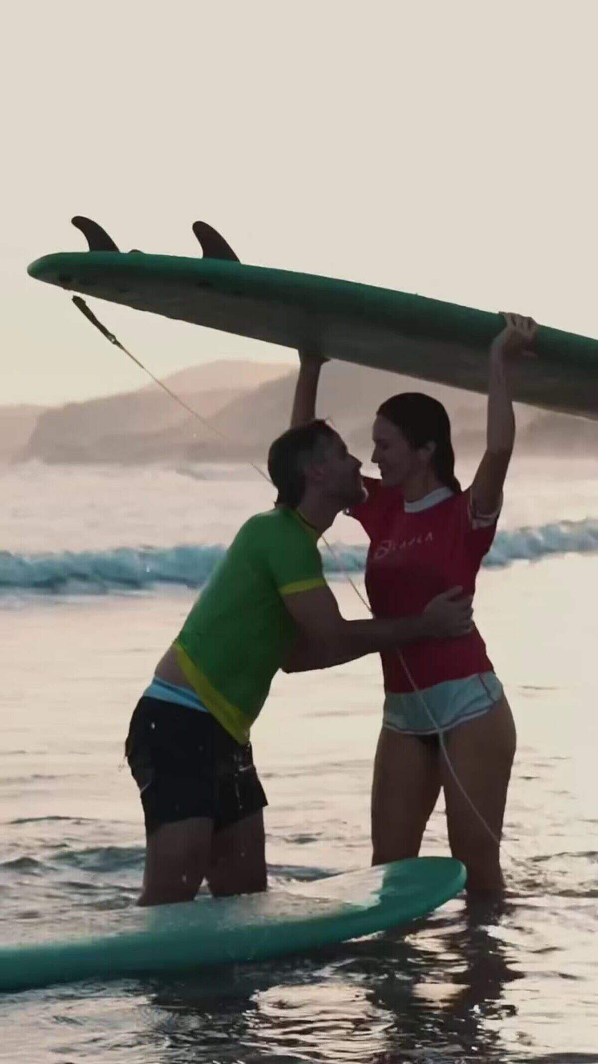 Pedro Alfonso y Paula Chaves se besan en la playa mientras sostienen tablas de surf
