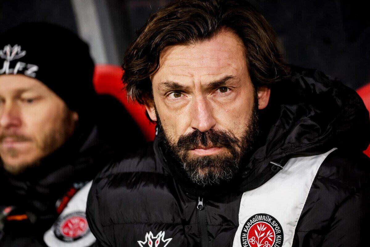 Andrea Pirlo con expresión seria en el banquillo durante un partido de fútbol