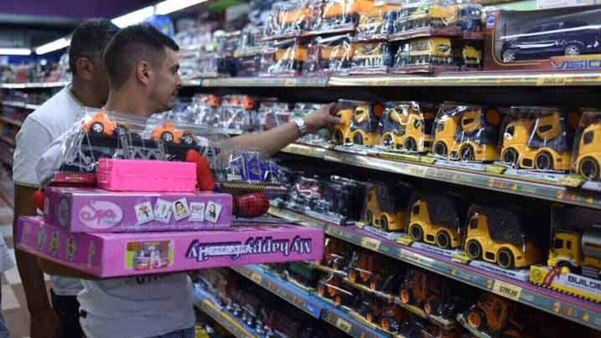 Hombre seleccionando juguetes en una tienda mientras sostiene una caja con el juguete Squeezy Dumpling