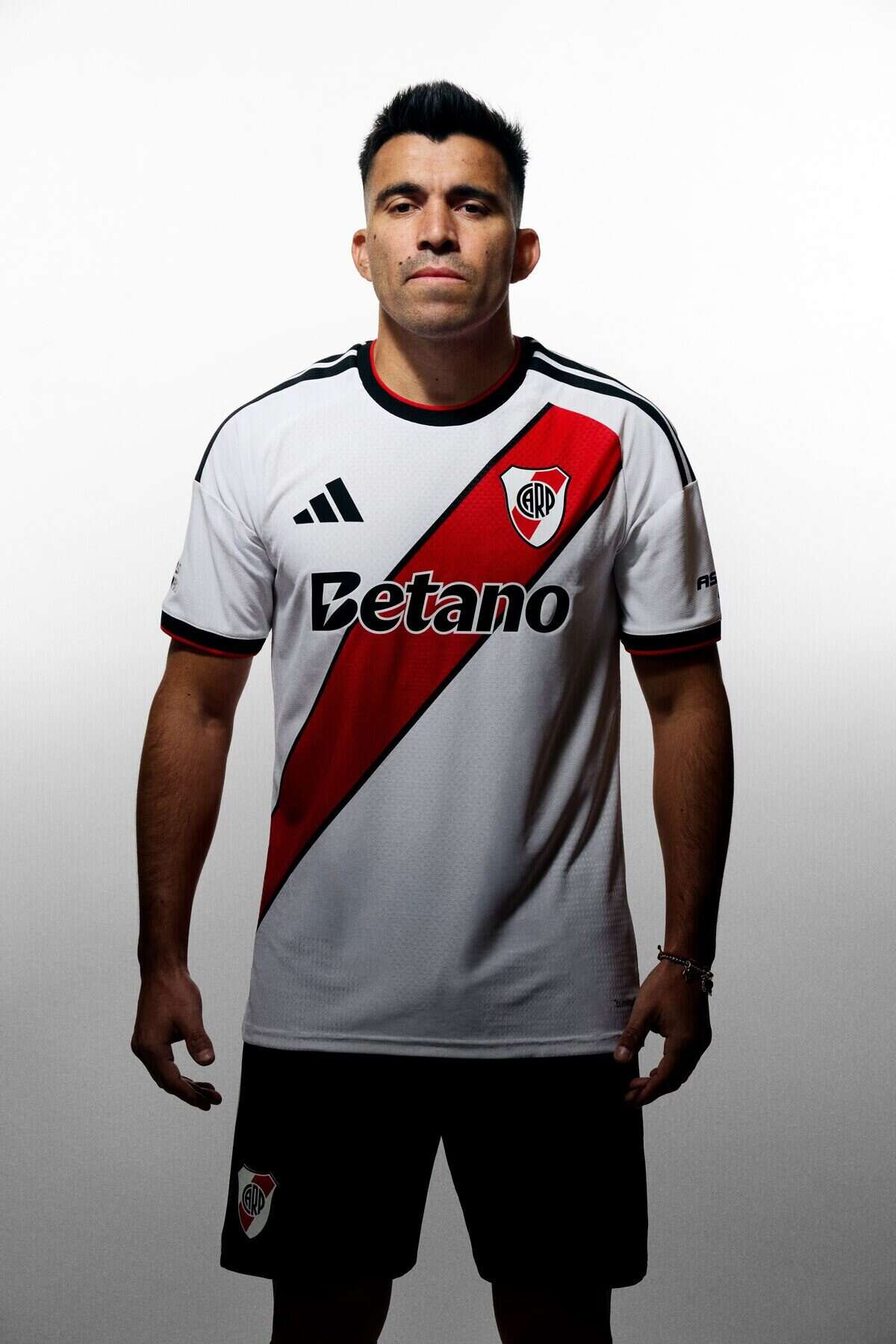 Jugador de River Plate vistiendo la nueva camiseta titular 2026/2027 con diseño inspirado en los primeros escudos del club