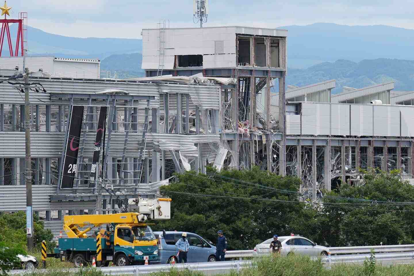 Edificio dañado por el terremoto en Kyushu, Japón, con vehículos de emergencia en la escena