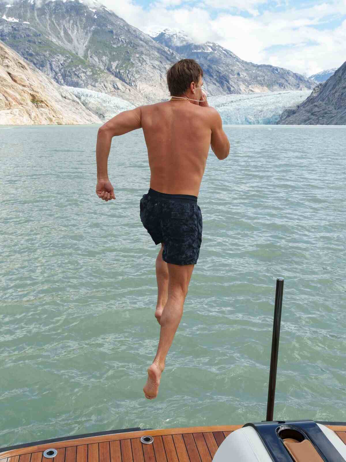 Tom Brady saltando al agua desde un barco en Alaska