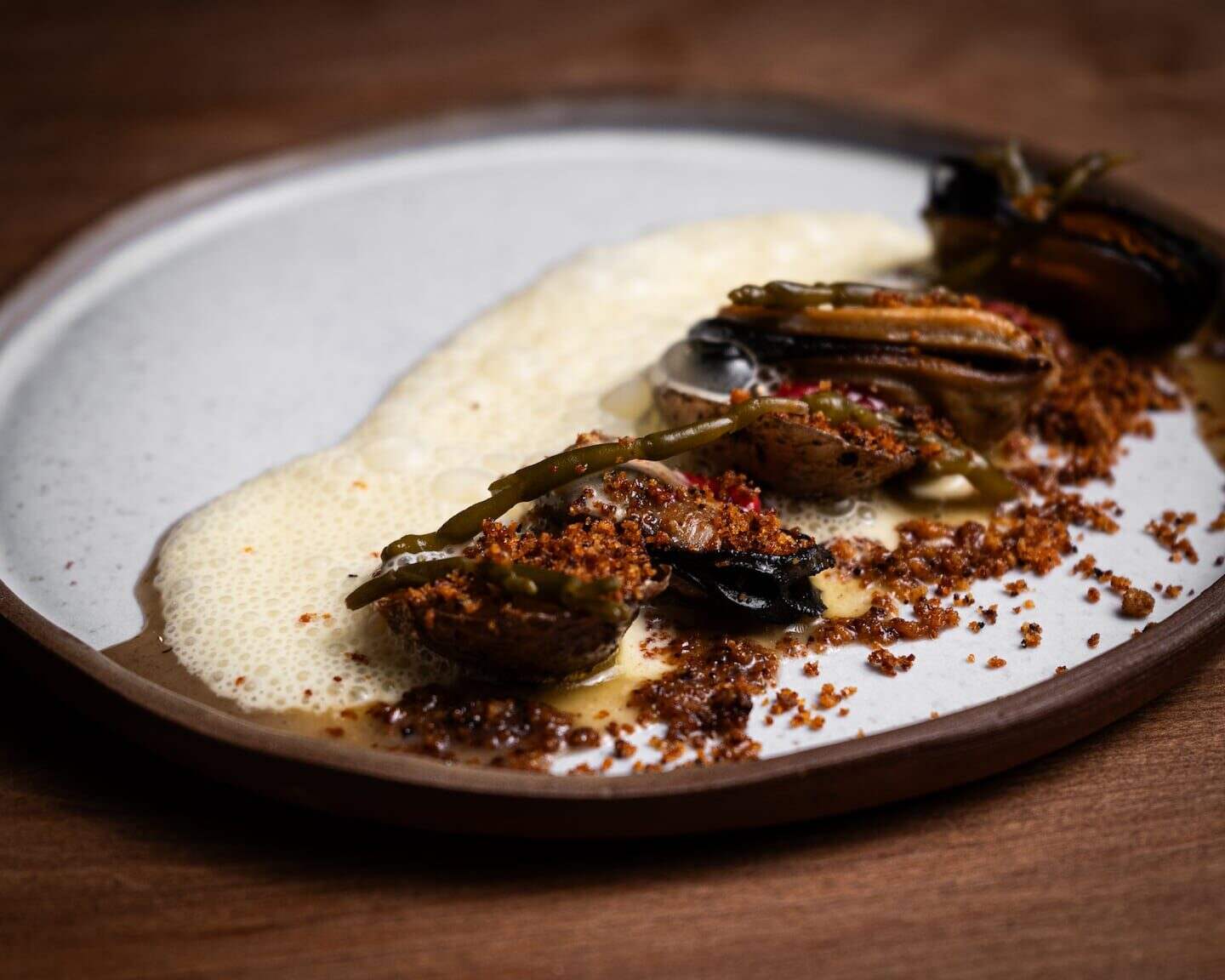 Plato gourmet con mariscos y espuma en un plato elegante