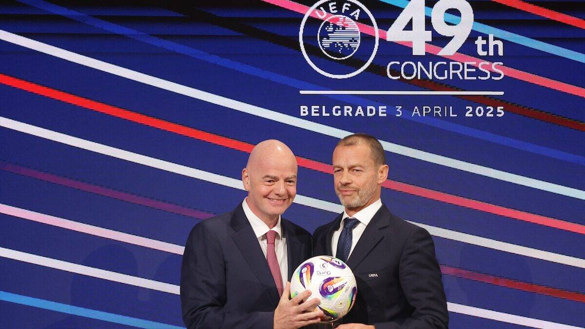 Dos hombres sosteniendo un balón de fútbol durante el congreso de la UEFA en Belgrado