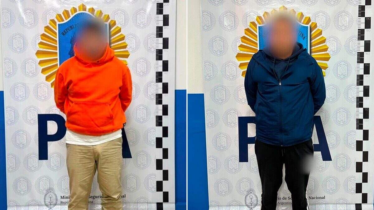 Dos hombres en un fondo institucional del Ministerio de Seguridad Nacional de Argentina
