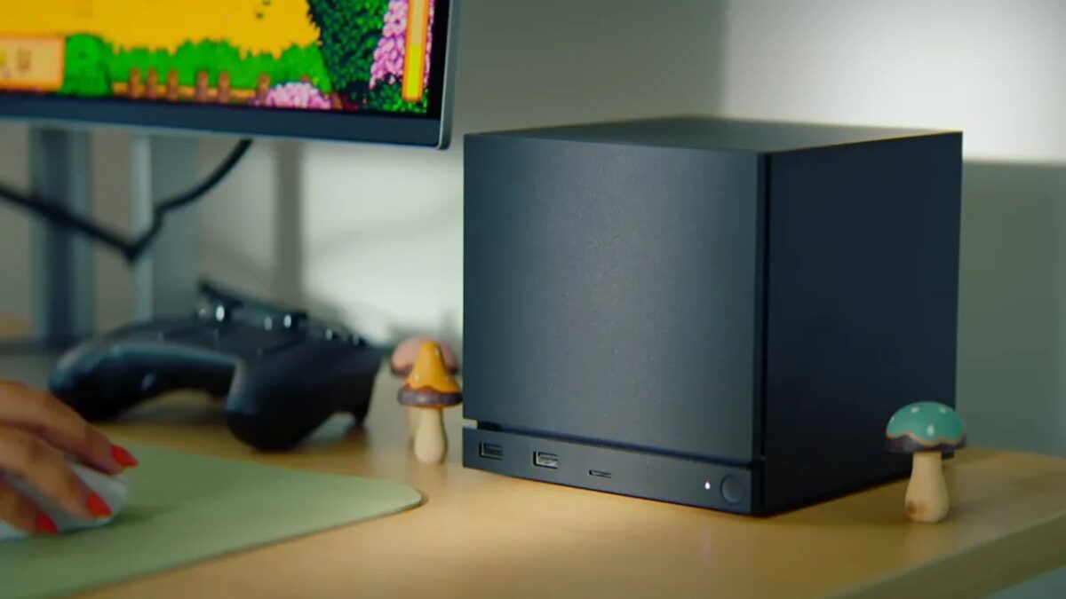 Steam Machine de Valve en un escritorio junto a un controlador y figuras decorativas