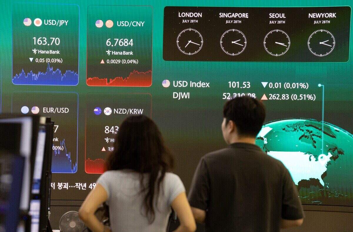 Personas observando pantallas de información financiera en Wall Street