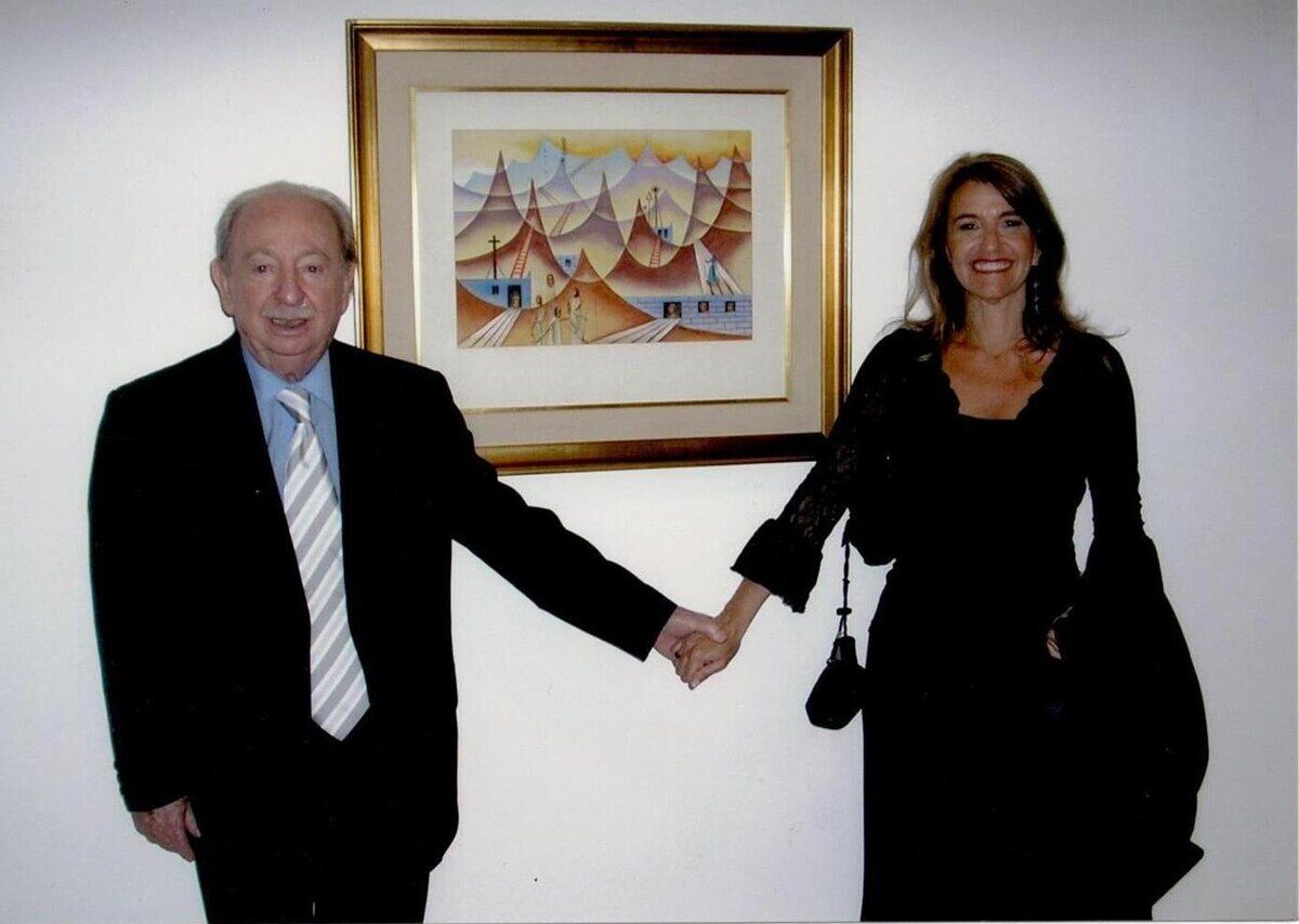Xul Solar junto a una mujer sosteniéndose de la mano frente a una obra de arte