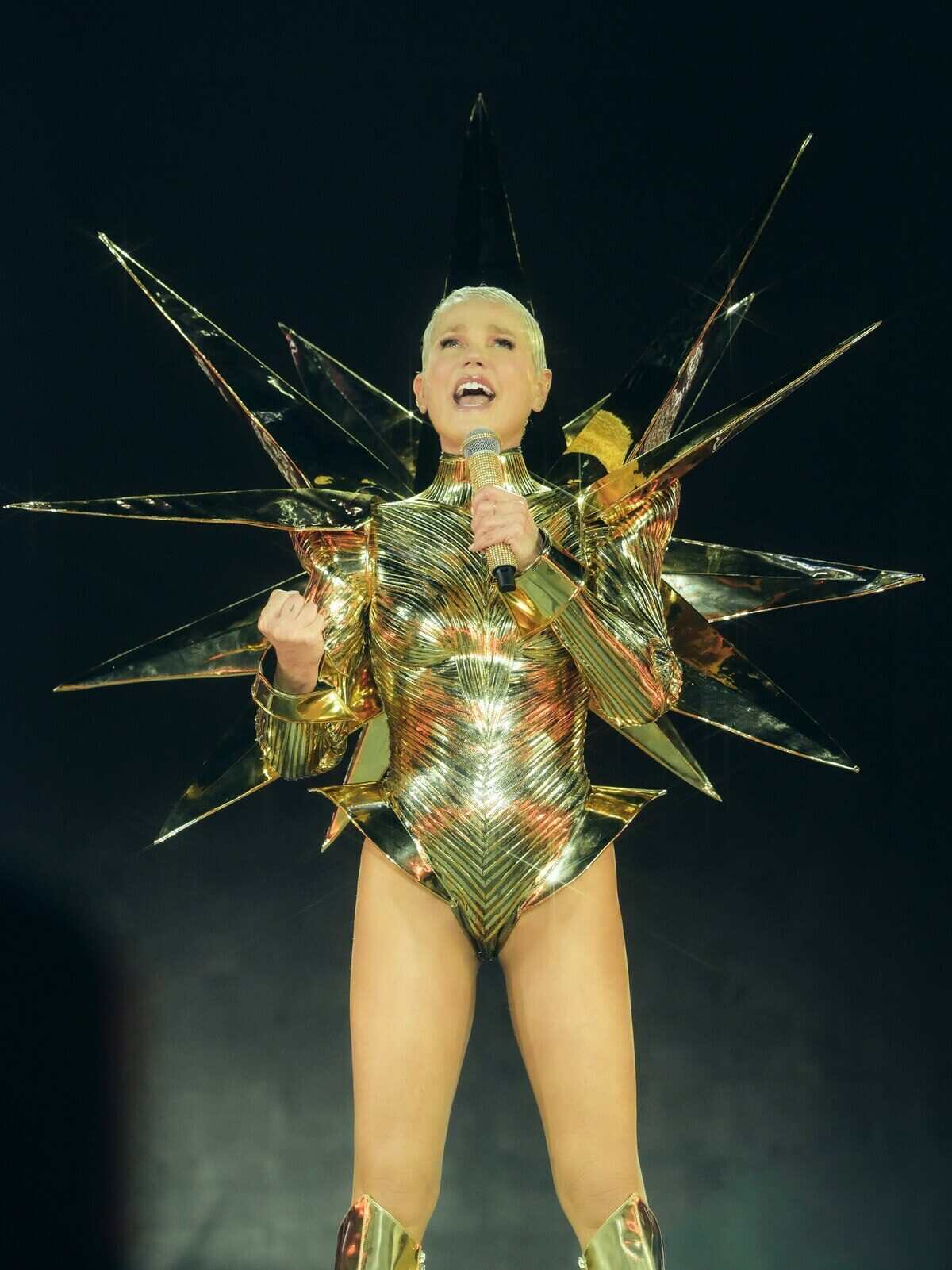 Xuxa en un espectáculo en San Pablo, vestida con un traje dorado y brillante